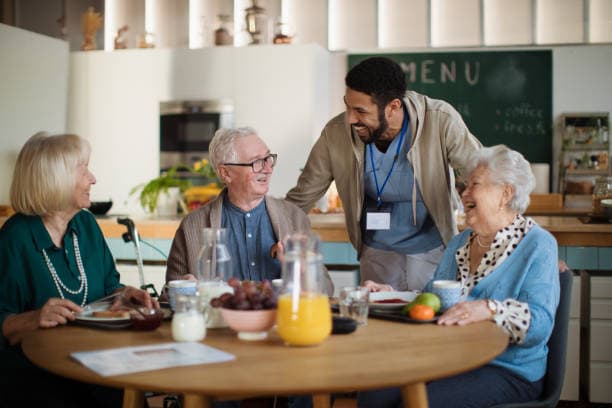 man with two elderly people a a table with food